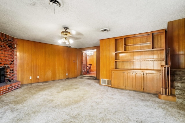 520 Circleview Dr S, Hurst, TX 76054 - unfurnished living room with a fireplace, a ceiling fan, a textured ceiling, light carpet, and wooden walls