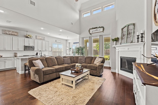 3620 Brahman Ct, Mckinney, TX 75071 - living room featuring a fireplace, dark wood finished floors, plenty of natural light, recessed lighting, and a towering ceiling