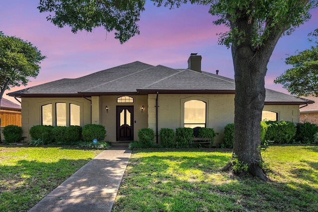 225 Wildwood Dr, Desoto, TX 75115 - view of front of home with a chimney, brick siding, a lawn, and a shingled roof
