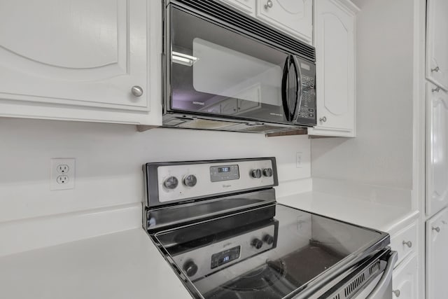 225 Wildwood Dr, Desoto, TX 75115 - kitchen featuring stainless steel electric range oven, black microwave, white cabinetry, and light countertops