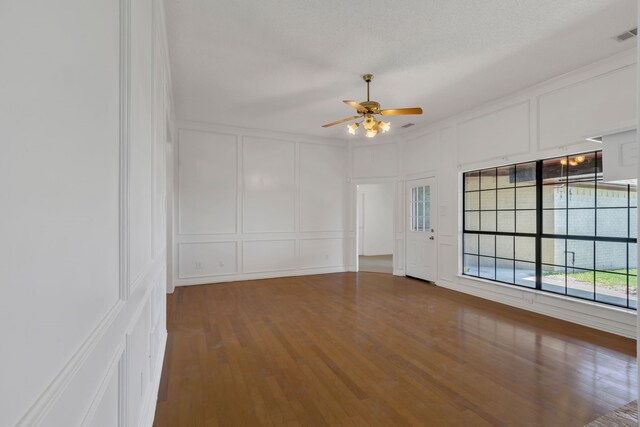 225 Wildwood Dr, Desoto, TX 75115 - empty room featuring a decorative wall, ceiling fan, and wood finished floors