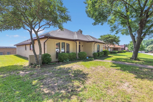 225 Wildwood Dr, Desoto, TX 75115 - view of front of home with a front lawn, a chimney, and brick siding
