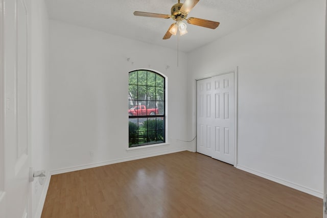 225 Wildwood Dr, Desoto, TX 75115 - spare room with wood finished floors, a ceiling fan, and baseboards