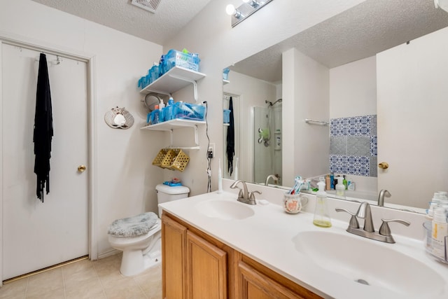1516 Englewood Dr, Rockwall, TX 75032 - bathroom featuring a textured ceiling, a shower, tile patterned flooring, toilet, and double vanity