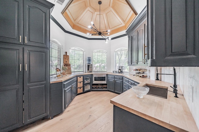 1495 Bent Trail Cir, Southlake, TX 76092 - kitchen featuring a chandelier, ornamental molding, light wood finished floors, decorative light fixtures, and butcher block counters