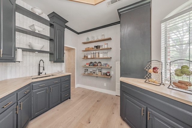 1495 Bent Trail Cir, Southlake, TX 76092 - kitchen featuring open shelves, a sink, light wood-type flooring, backsplash, and baseboards