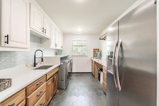 1495 Bent Trail Cir, Southlake, TX 76092 - kitchen with stainless steel fridge, washer and dryer, a sink, light countertops, and decorative backsplash
