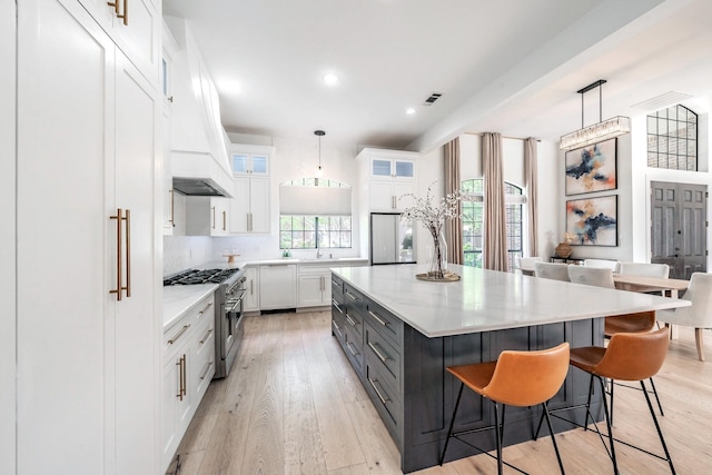 1495 Bent Trail Cir, Southlake, TX 76092 - kitchen with stainless steel range, white cabinetry, glass insert cabinets, light countertops, and recessed lighting