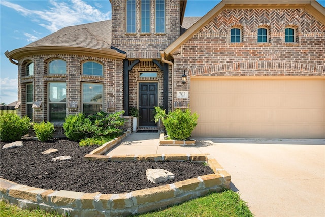 703 The Trails Dr, Blue Ridge, TX 75424 - french country home with brick siding, roof with shingles, concrete driveway, and a garage