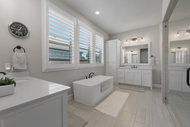 2121 Glenbrook St, Haslet, TX 76052 - bathroom with two vanities, a soaking tub, and baseboards