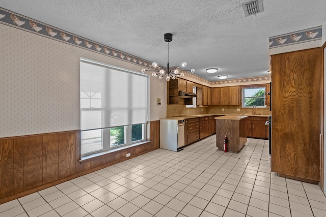 7725 Westwind Dr, Fort Worth, TX 76179 - kitchen featuring a chandelier, a sink, a textured ceiling, light countertops, and under cabinet range hood
