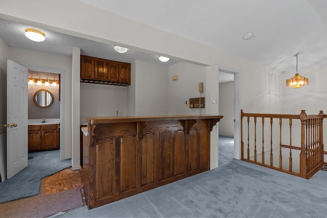 7725 Westwind Dr, Fort Worth, TX 76179 - kitchen with light carpet, a kitchen bar, a peninsula, and hanging light fixtures