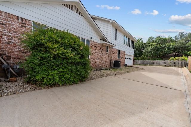 7725 Westwind Dr, Fort Worth, TX 76179 - view of home's exterior featuring brick siding, driveway, a garage, and cooling unit