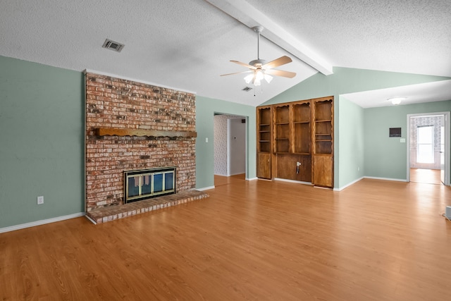 7725 Westwind Dr, Fort Worth, TX 76179 - unfurnished living room with wood finished floors, a ceiling fan, a textured ceiling, a brick fireplace, and baseboards