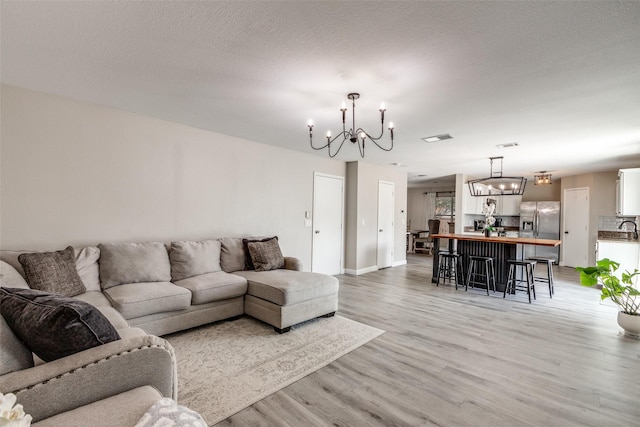 2308 Pheasant Run, Melissa, TX 75454 - living room featuring a chandelier, light wood-type flooring, and baseboards