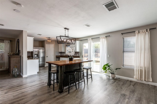 2308 Pheasant Run, Melissa, TX 75454 - kitchen with butcher block countertops, stainless steel refrigerator with ice dispenser, dark wood finished floors, white cabinets, and baseboards