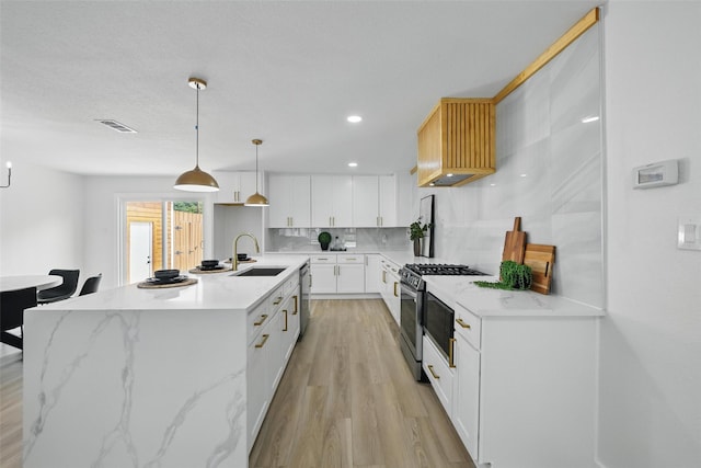 3173 Catamore Ln, Dallas, TX 75229 - kitchen featuring stainless steel appliances, a sink, backsplash, light wood finished floors, and white cabinetry