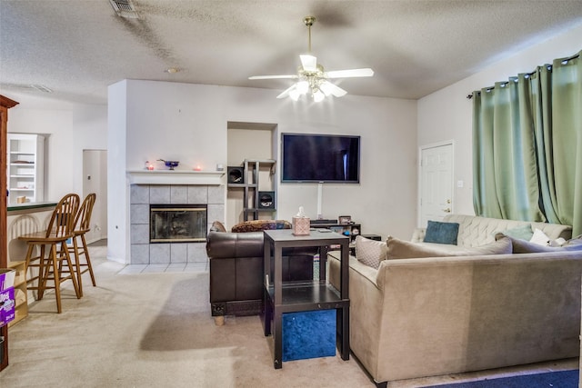 6837 Beverly Glen Dr, Fort Worth, TX 76132 - living room featuring a textured ceiling, ceiling fan, a fireplace, and carpet