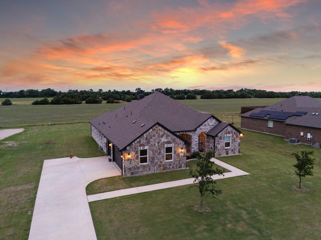 123 Cedar Elm Ln, Nevada, TX 75173 - view of front of home with stone siding, driveway, a lawn, a garage, and cooling unit