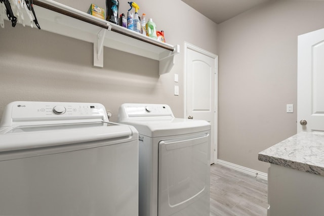 123 Cedar Elm Ln, Nevada, TX 75173 - laundry room featuring light wood finished floors, washing machine and dryer, and baseboards
