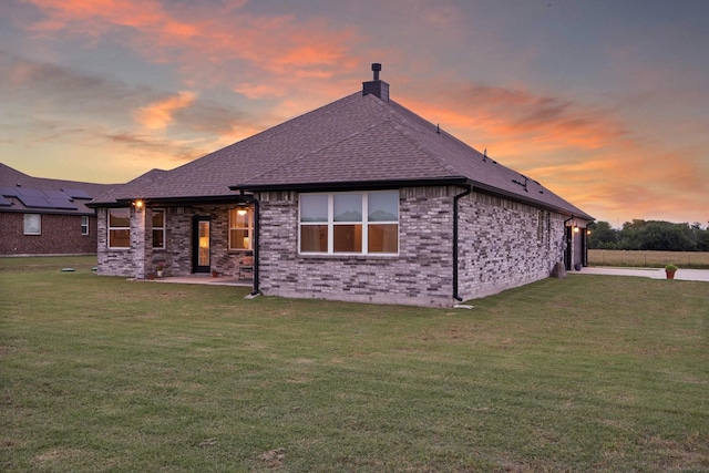 123 Cedar Elm Ln, Nevada, TX 75173 - rear view of property with a chimney, a yard, brick siding, and roof with shingles