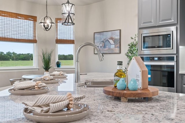 123 Cedar Elm Ln, Nevada, TX 75173 - kitchen view of appliances with stainless steel finishes, light stone counters, a chandelier, a sink, and pendant lighting