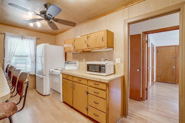 1245 Hodgson St, Fort Worth, TX 76115 - kitchen featuring white appliances, crown molding, light wood-type flooring, ceiling fan, and wood walls