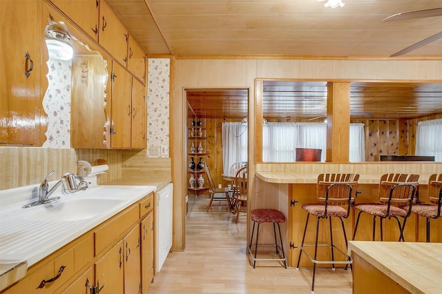 1245 Hodgson St, Fort Worth, TX 76115 - kitchen with wooden ceiling, light wood finished floors, a kitchen breakfast bar, light countertops, and white dishwasher
