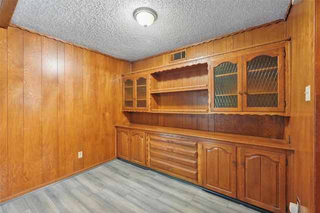 6330 Autumn Woods Trl, Dallas, TX 75232 - interior space with light wood-type flooring, a textured ceiling, and wood walls