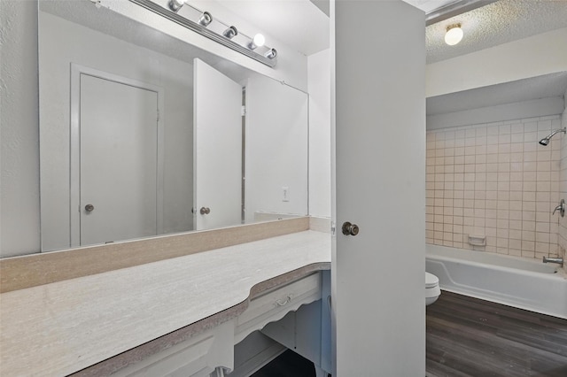 6330 Autumn Woods Trl, Dallas, TX 75232 - bathroom featuring toilet, vanity, wood finished floors, shower / bath combination, and a textured ceiling