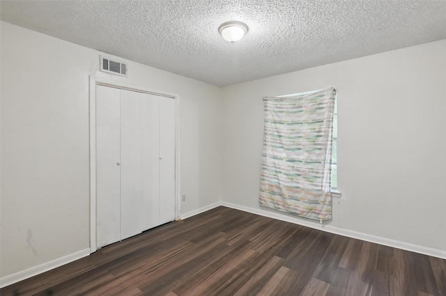 6330 Autumn Woods Trl, Dallas, TX 75232 - unfurnished bedroom with dark wood-style floors, a closet, baseboards, and a textured ceiling