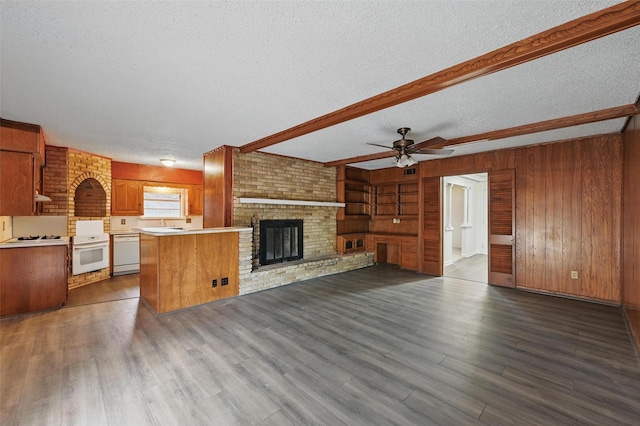 6330 Autumn Woods Trl, Dallas, TX 75232 - unfurnished living room with a textured ceiling, beamed ceiling, wood finished floors, wood walls, and a ceiling fan