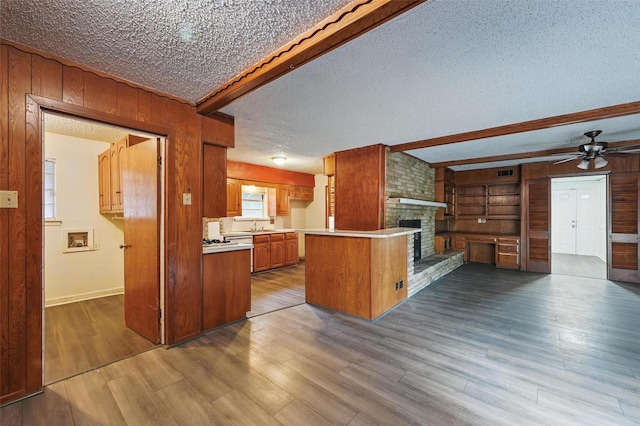 6330 Autumn Woods Trl, Dallas, TX 75232 - kitchen with wooden walls, a textured ceiling, a brick fireplace, open floor plan, and a sink
