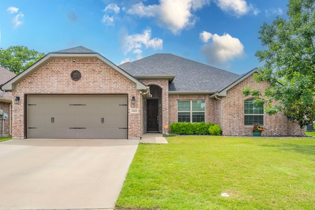 313 Donna Cir, Granbury, TX 76049 - view of front facade with roof with shingles, brick siding, an attached garage, driveway, and a front yard