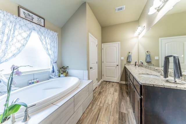 313 Donna Cir, Granbury, TX 76049 - full bathroom with double vanity, a bath, wood finished floors, and baseboards