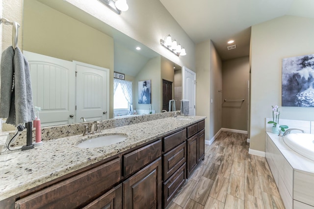 313 Donna Cir, Granbury, TX 76049 - full bath featuring double vanity, vaulted ceiling, a bath, baseboards, and recessed lighting