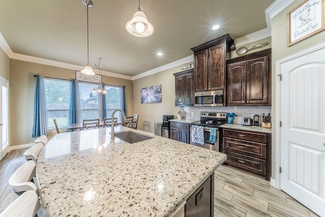 313 Donna Cir, Granbury, TX 76049 - kitchen featuring stainless steel appliances, a sink, dark brown cabinetry, a kitchen island with sink, and light stone countertops