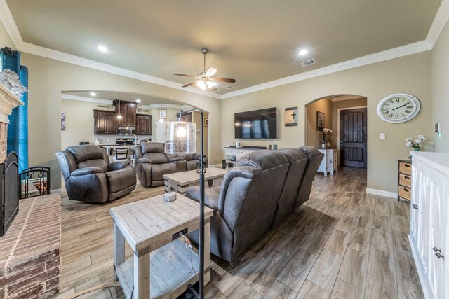 313 Donna Cir, Granbury, TX 76049 - living room featuring arched walkways, ceiling fan, baseboards, wood finished floors, and crown molding