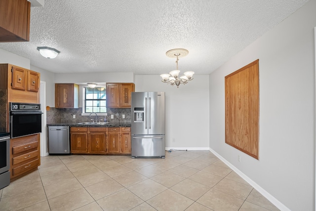 190 Rs County Road 4330, Point, TX 75472 - kitchen with appliances with stainless steel finishes, a sink, decorative backsplash, light tile patterned floors, and brown cabinetry
