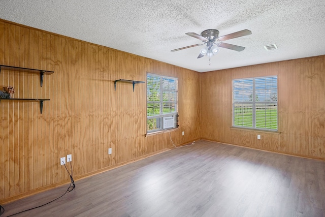 190 Rs County Road 4330, Point, TX 75472 - empty room with wood finished floors, a textured ceiling, ceiling fan, wooden walls, and cooling unit