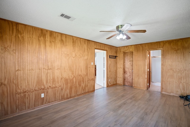 190 Rs County Road 4330, Point, TX 75472 - spare room with a ceiling fan, wood finished floors, wooden walls, a textured ceiling, and baseboards