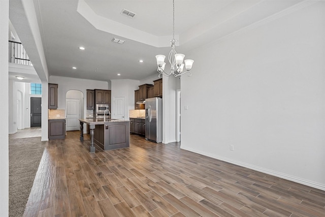 15232 Primrose Garden Ct, Aledo, TX 76008 - kitchen with stainless steel appliances, a breakfast bar, arched walkways, ornamental molding, and light countertops
