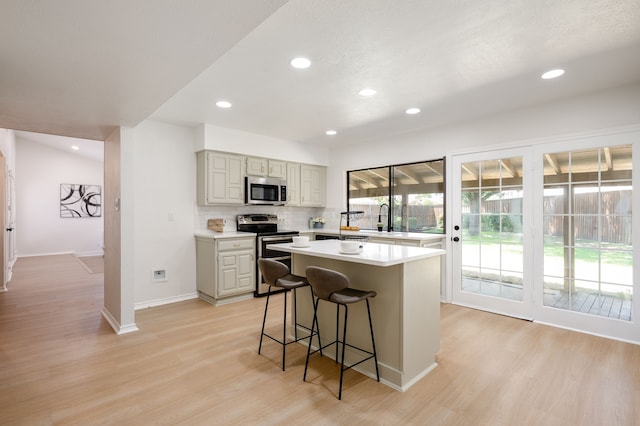4218 Aralia St, Mesquite, TX 75150 - kitchen with appliances with stainless steel finishes, light wood-style flooring, light countertops, a center island, and recessed lighting