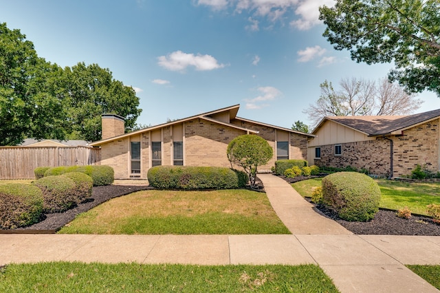 4218 Aralia St, Mesquite, TX 75150 - mid-century modern home with brick siding, a chimney, and board and batten siding