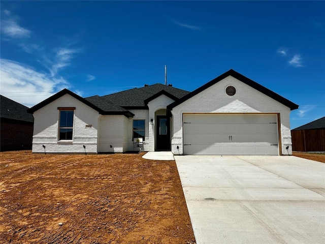 1406 Oleander Dr, Tolar, TX 76476 - view of front of house featuring brick siding, concrete driveway, and a garage