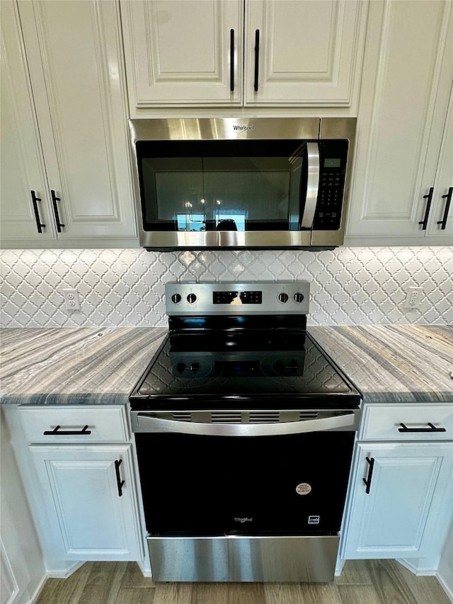 1406 Oleander Dr, Tolar, TX 76476 - kitchen featuring stainless steel appliances, backsplash, white cabinets, and light stone countertops