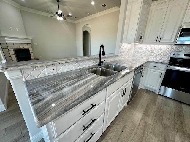 1406 Oleander Dr, Tolar, TX 76476 - kitchen featuring appliances with stainless steel finishes, a sink, wood finished floors, a ceiling fan, and stone countertops