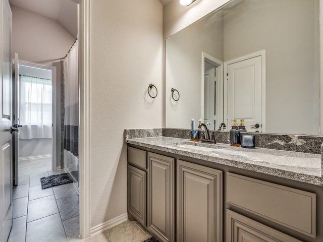 1241 Ronald St, Desoto, TX 75115 - bathroom featuring vanity, shower / bath combo with shower curtain, tile patterned floors, and baseboards