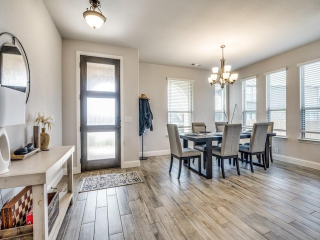 1241 Ronald St, Desoto, TX 75115 - dining area featuring a chandelier, light wood-style flooring, and baseboards