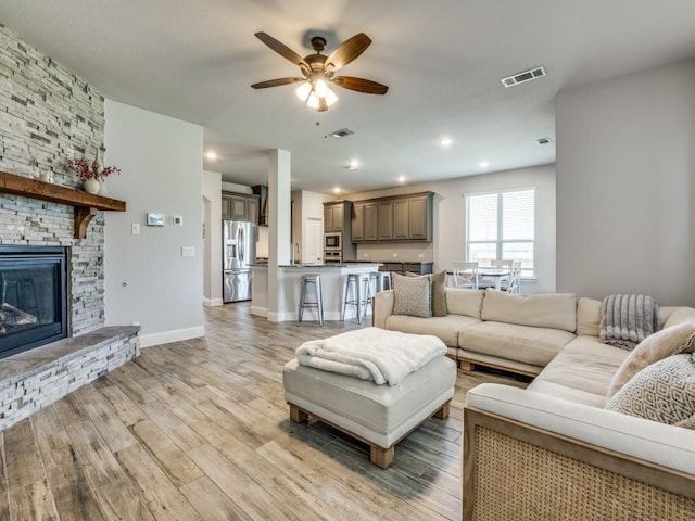 1241 Ronald St, Desoto, TX 75115 - living area featuring light wood-style floors, ceiling fan, a stone fireplace, and baseboards
